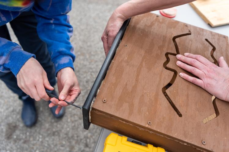 Mikayla Schuyler and Dr. Kim Thompson put a wooden roof on a bat dwelling