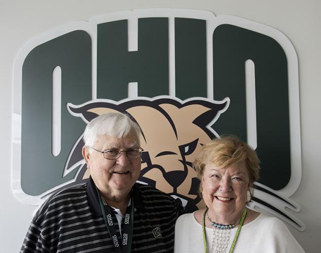 Alumni Tom and Gwen Weihe pose in front of the OHIO logo