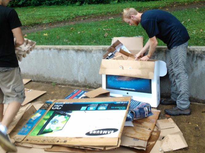 Zero Waste team member Brandt Taylor flattens move-in cardboard for recycling.