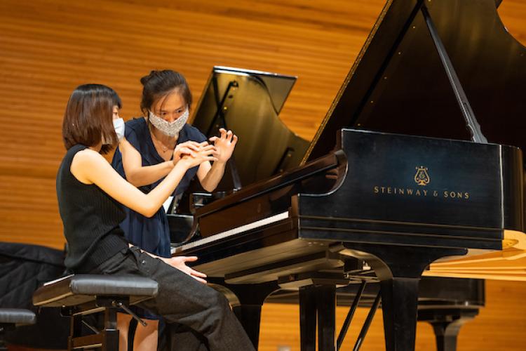 Qing Jiang works with a student.