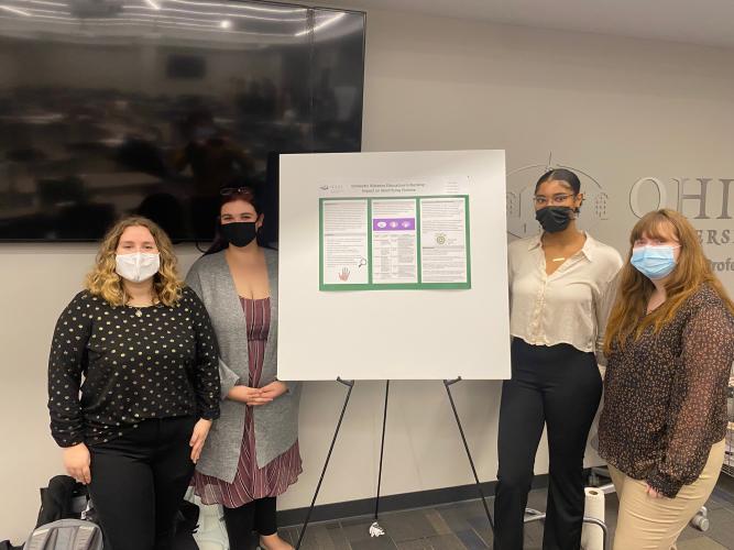 OHIO students stand by a poster board