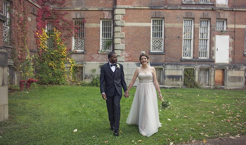 OHIO graduates Russell Morrow and Kasey Daniel are pictured on their October 2016 wedding day outside a building at The Ridges in Athens.