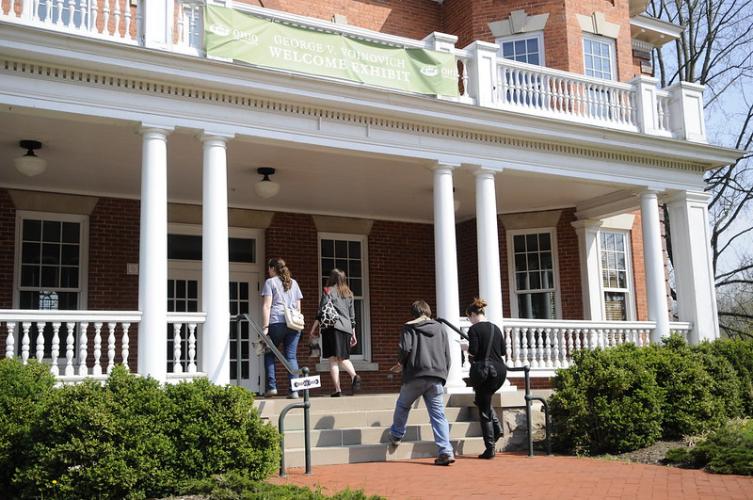 People walking into the Voinovich School building