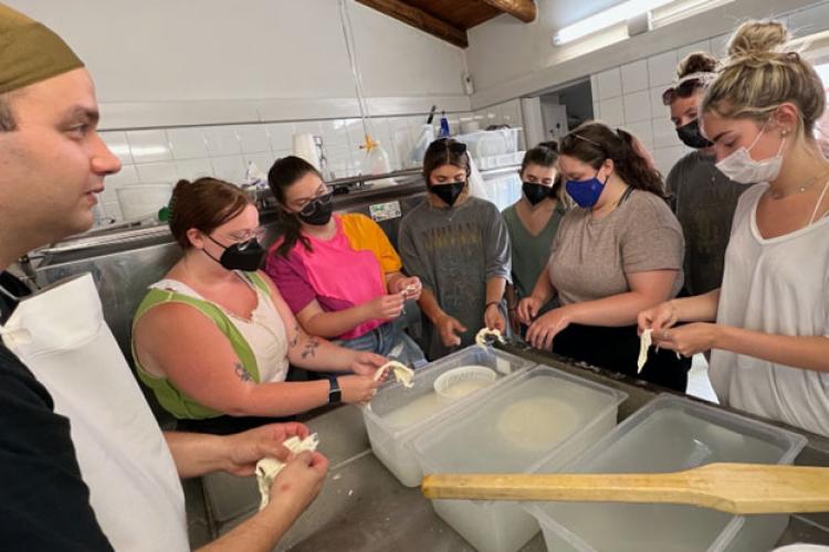 Master cheesemaker Giuseppe Selvaggio, left, teaches students how to make stracciatella. Students from left: Emily McCarty, Emily Jones, Sydnie Kilgour, Maya Roth-Wadsworth, Faith Laughlin, Jackie Augustine and Lauren Hayes.