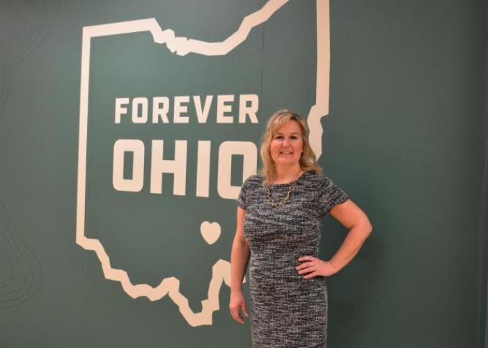 Photo of Heather Cameron in front of a large "Forever OHIO" graphic