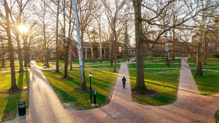A staff member walks across College Green.