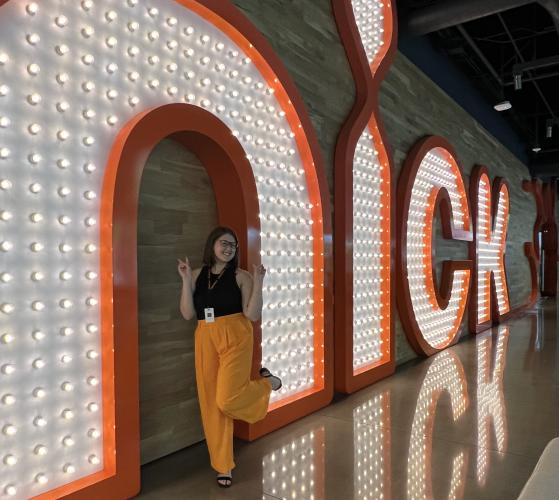 Allison Irey poses for a picture in front of a light-up 