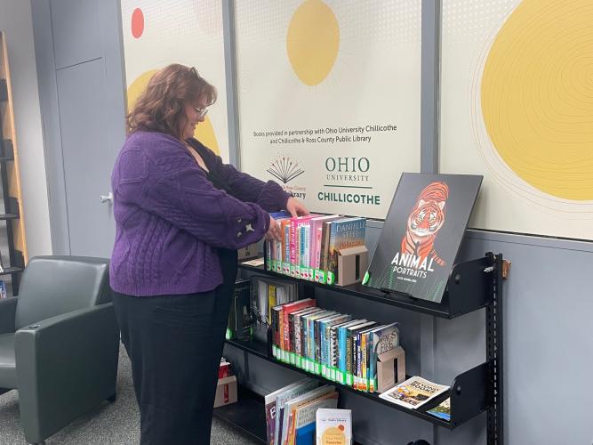 Emma Adams browses the community collection at Quinn Library