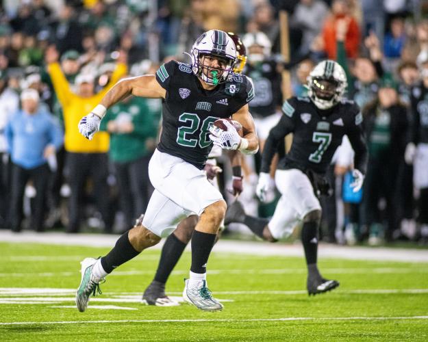 An OHIO football player runs with the ball in a game in Peden Stadium against Central Michigan University