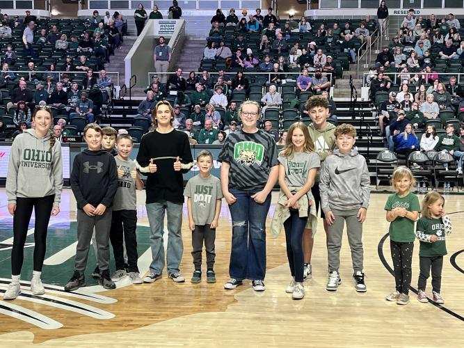 Participants of the Cat Camp diabetes day camp are shown posing for a photo on the basketball court at an OHIO Men's Basketball game