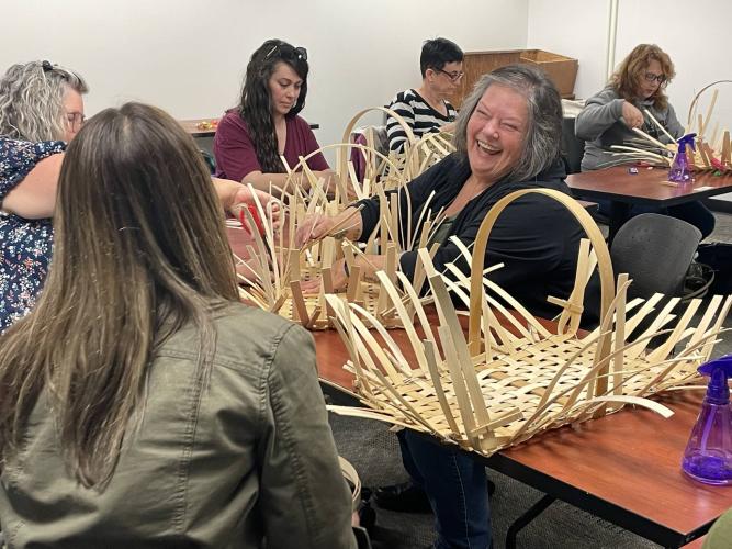instructor laughs while teaching basket-weaving class