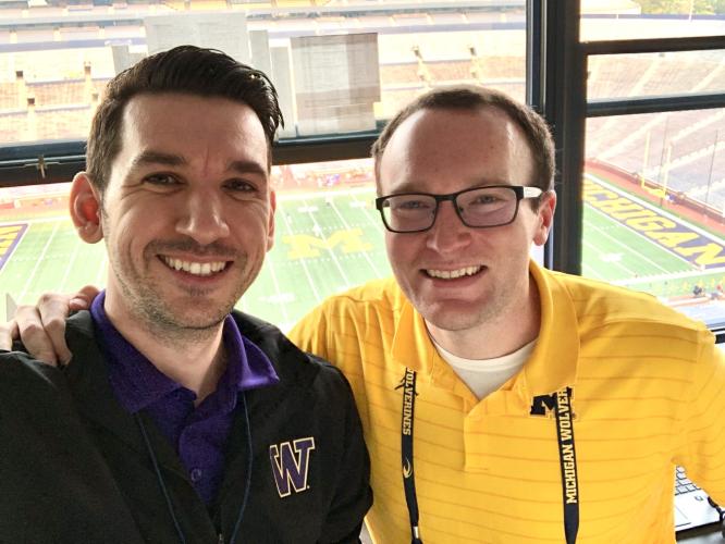 Tony Castricone and Brian Boesch  are shown in the broadcast booth at the University of Michigan football stadium in 2021