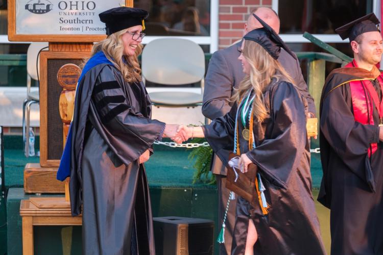 Dean Marinski shaking hands with graduate