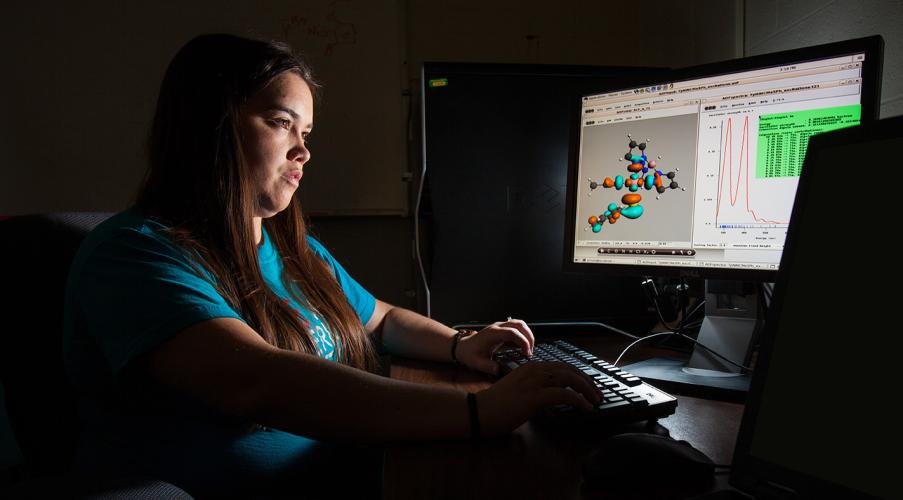 A chemistry student studying at a desktop computer. 