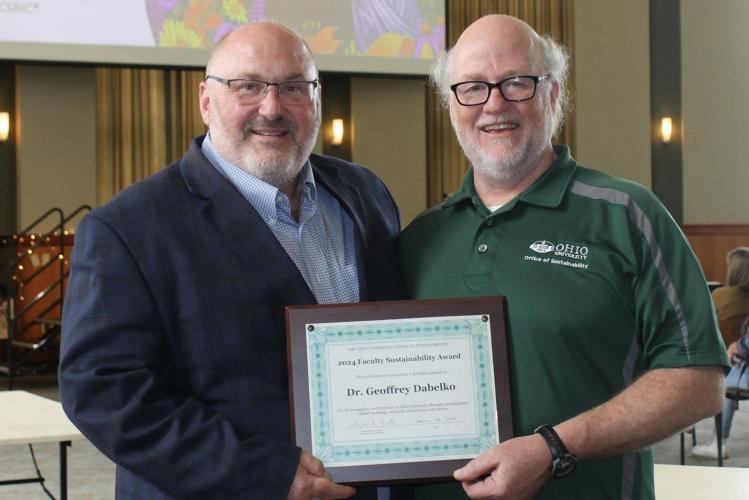 Geoff Dabelko and Sam Crowl hold the Faculty Sustainability Award that as presented to Dabelko