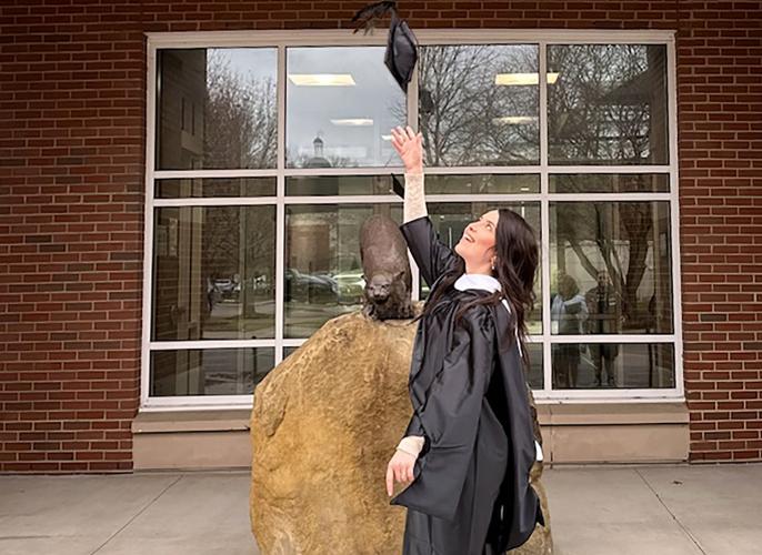 Nicole Meier tossing her graduation cap in the air.