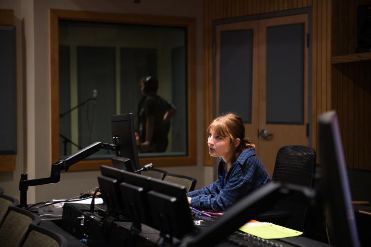 A student is shown using media equipment at the High School Media Workshop