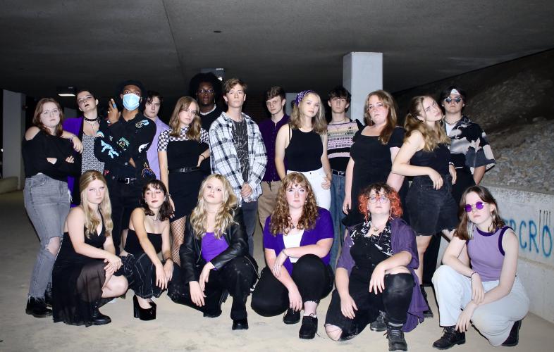 The members of Dynamics Acapella pose wearing purple and black