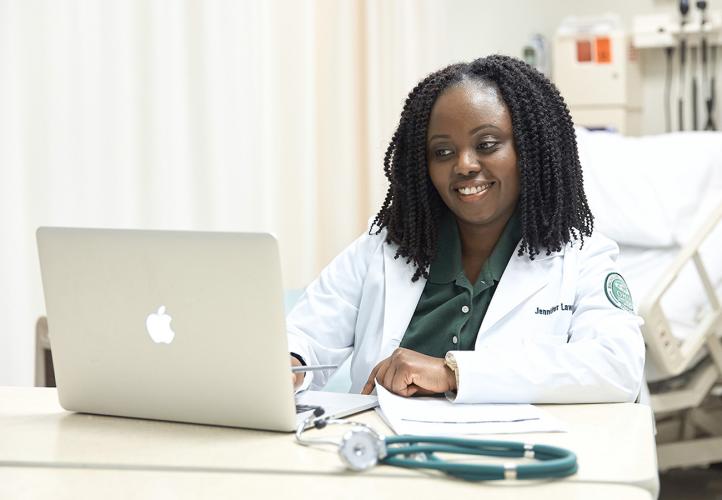 An OHIO nursing student working on a laptop in a medical setting. 