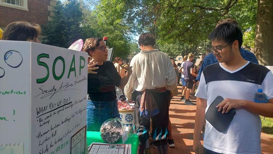 A student peruses the display for SOAP at the Student Organization Fair