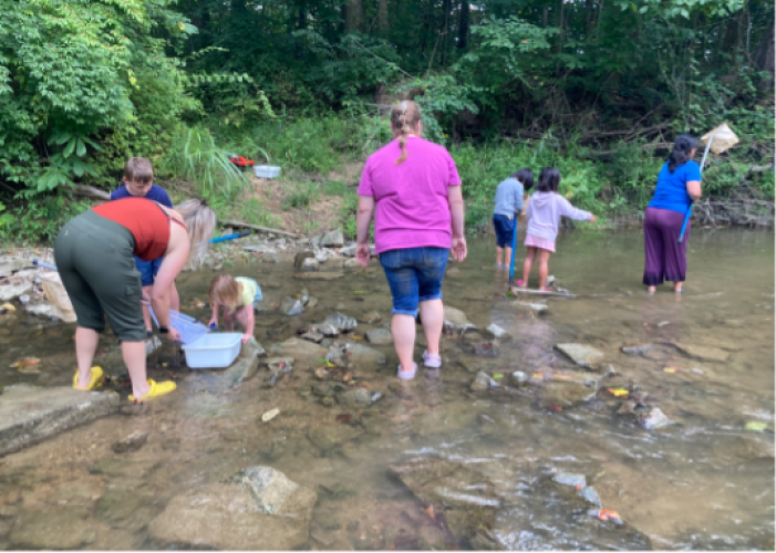 Students and teachers work  in a stream during a community STEM Day activity