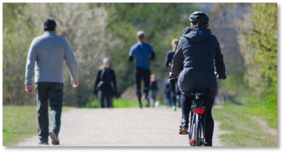 Individuals walk and ride bicycles outside