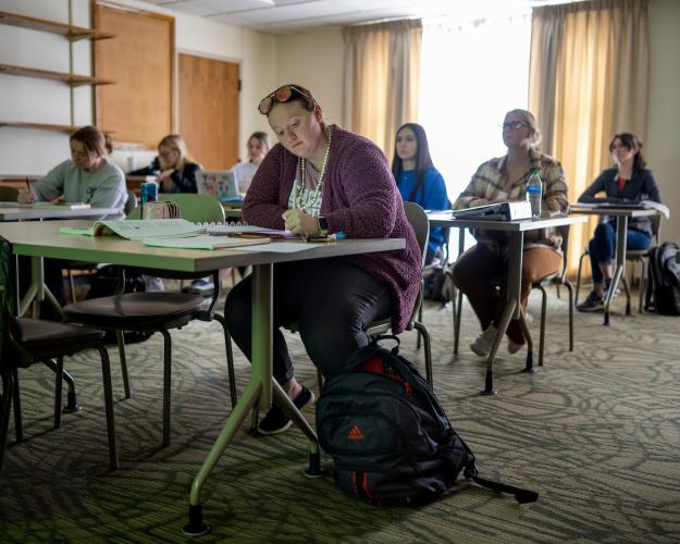 students sitting at tables in classroom