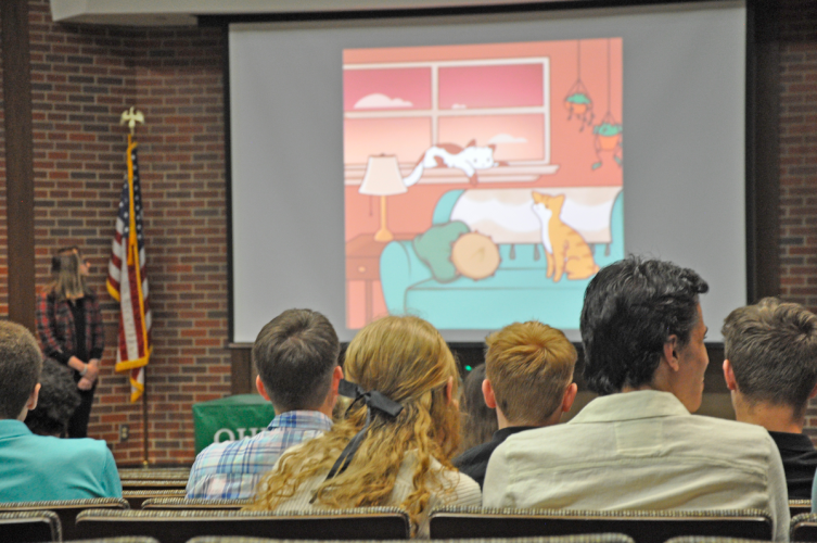 students watching EMPixx submissions in auditorium