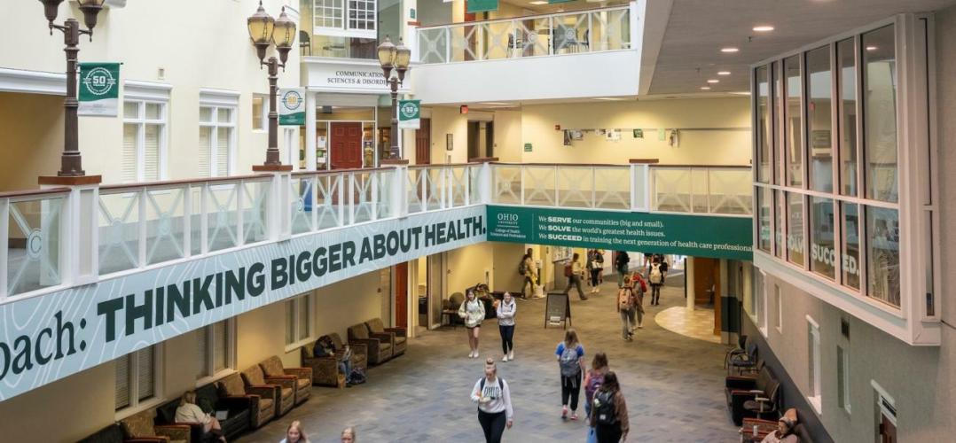 A photo from the second floor looking down at students walking through the Grover Center Atrium