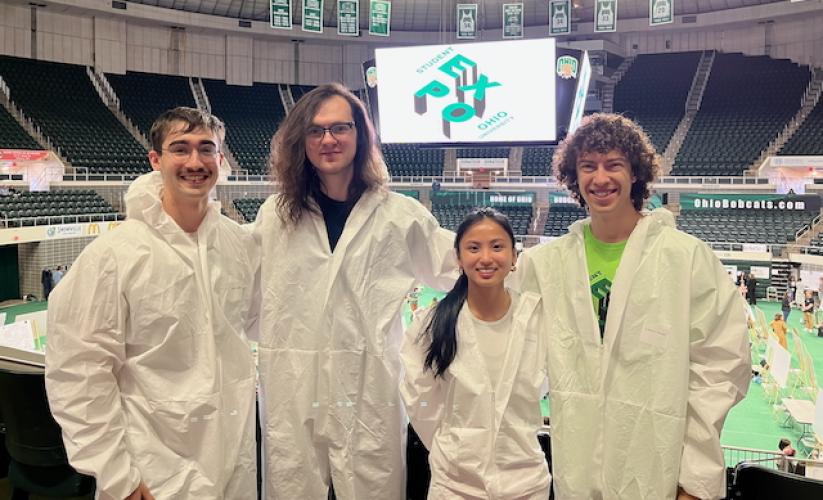 John Gilbert, Michael Cooney, Xiangsi Howard and Gabriel Havas stand in the Convocation Center during the Student Research Expo