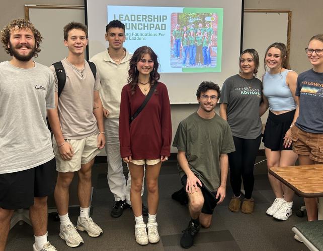 OHIO students in the Leadership Launchpad program stand together for a photo in front of a Leadership Launchpad PowerPoint slide