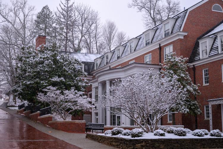 An OHIO residence hall and the trees and bushes around it are covered in snow