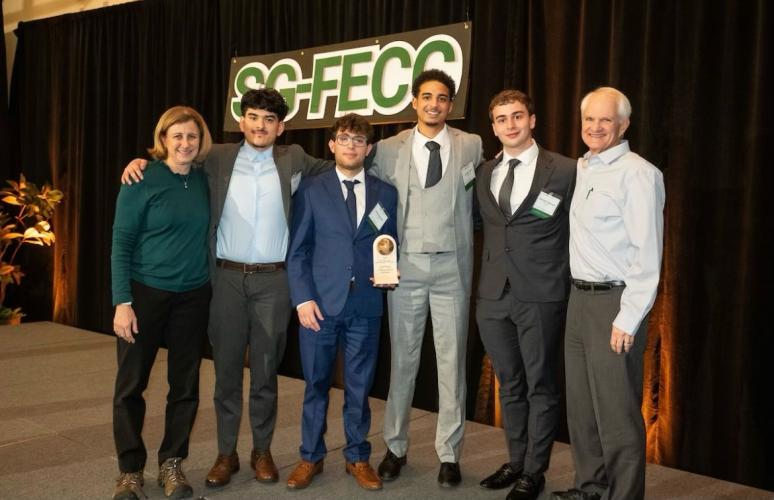 OHIO students and faculty pose for a photo in front of the SG-FECC sign at the Schlesinger Global Family Enterprise Case Competition.