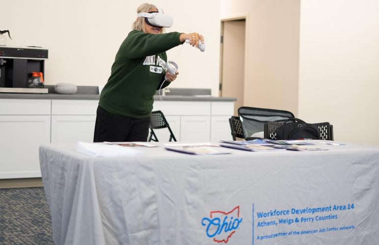 An individual is shown using a virtual reality headset and moving her arms