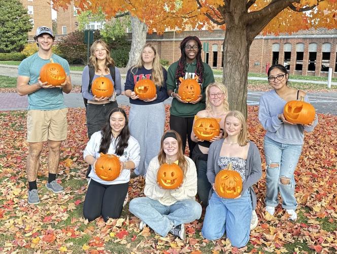 Learning Community students hold jack-o-lanterns outside on a fall day at Ohio University
