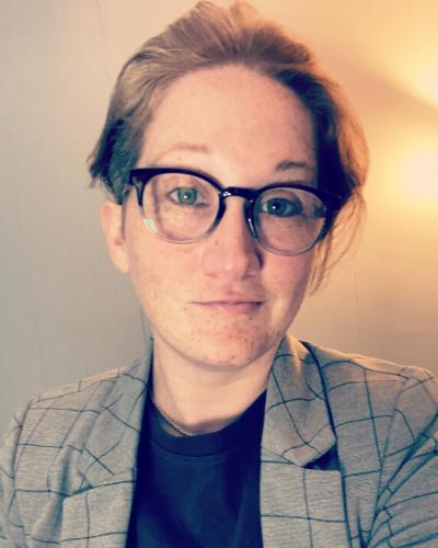 Headshot of woman with short hair, glasses, Blazer