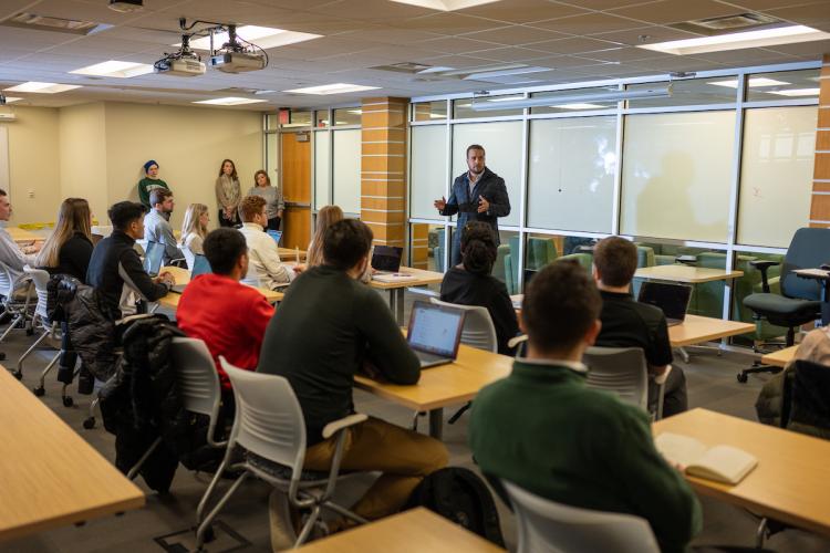 A faculty member teaches a course in front of an OHIO class
