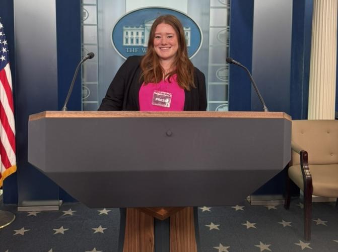 Abby Waechter stands behind a podium in a White House press room