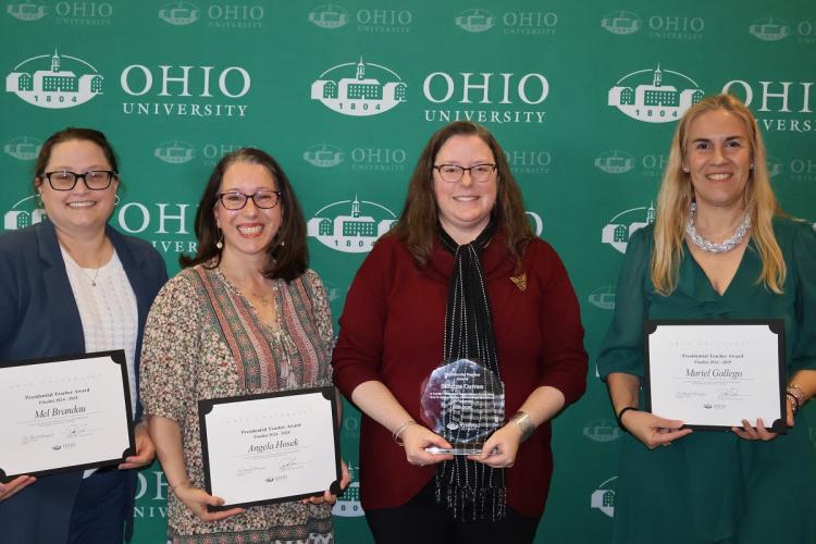 Mel Brandau, Angela, Hosek, Sabrina Curran and Murial Gallego hold their awards in front  of an Ohio University media wall