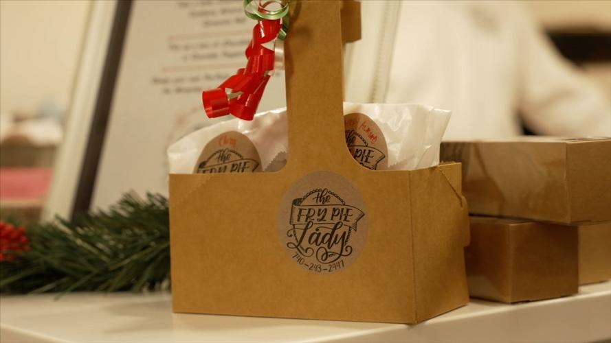an image of a paper bag on a decorated table, and the bag says The Fry Pie Lady - 740-243-2447