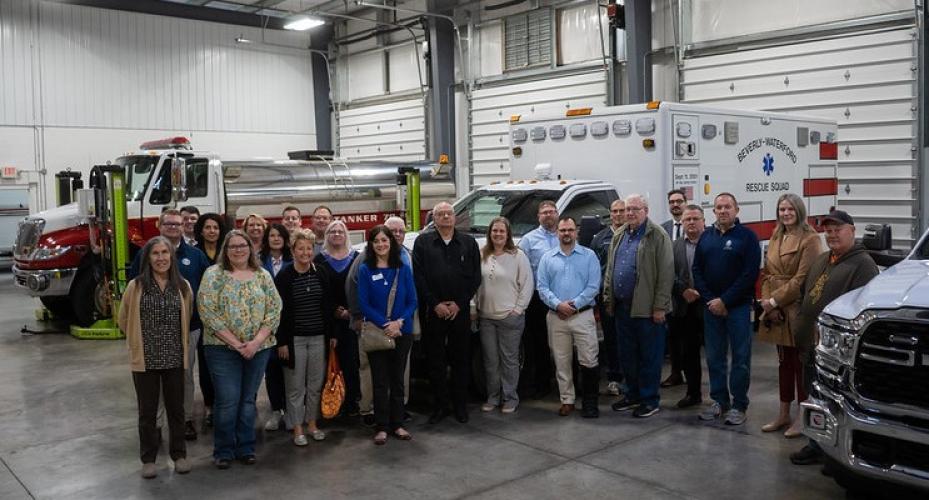 Members of the Mayors' Partnership for Progress pose for a group photo next to fire and rescue trucks