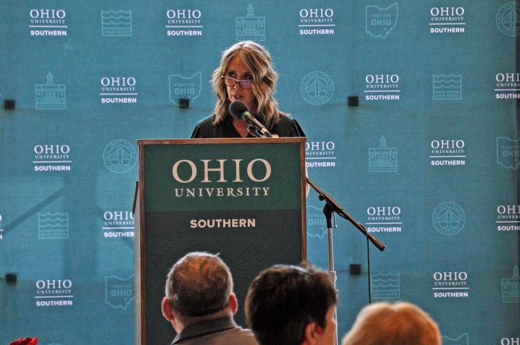 Dr. Marinski addresses audience behind podium.