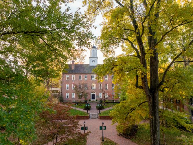 Cutler Hall is surrounded by colorful trees on the College Green on a day in fall