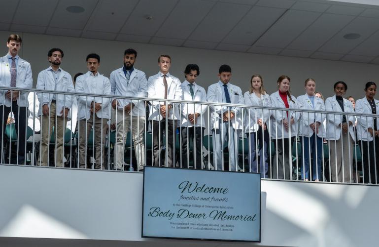 Students stand for a moment of silence during the Body Donor Memorial Service.