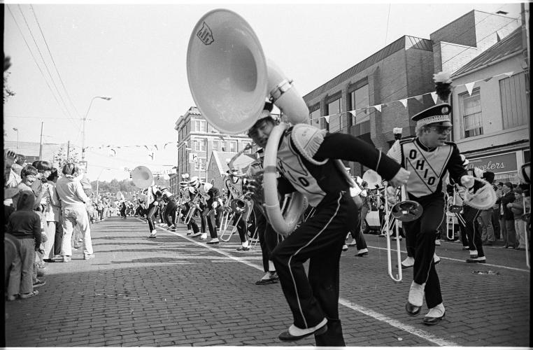 Marching 110 members perform on Court Street in this black and white image of a past Homecoming celebration at Ohio University