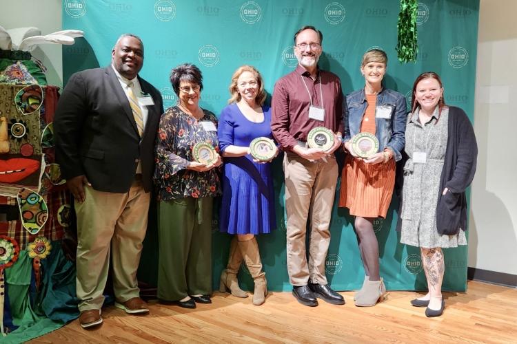 OHIO representative stand with community partner award winners, who are holding their awards