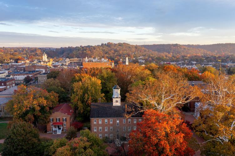 Cutler Hall is shown surrounded by colorful trees, with hilldsides in the background in this aerial image