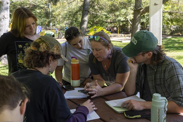 Natalie Kruse Daniels and others discuss a project while standing around a table outside