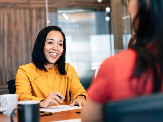 two women sitting at a table talking