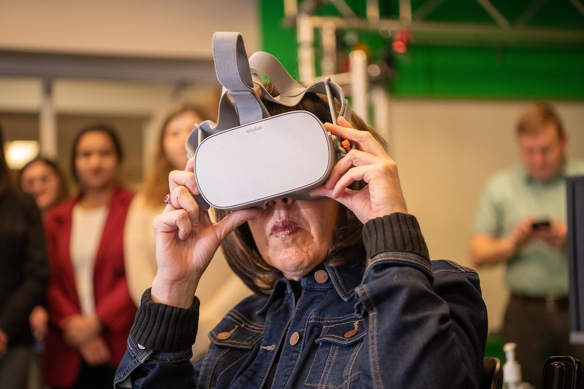 Anne Hazlett, Sr. Adviser For Rural Affairs views a virtual Narcan treatment developed in the Scripps College of Communication at Ohio University while students who've helped work on the simulation from the School of Nursing look on. 